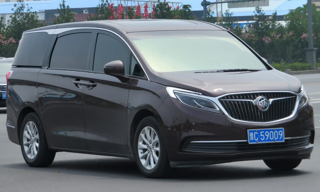Dark Buick GL8 business MPV photographed from the front and side.